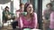 Front view of confident charming young retro woman drinking coffee looking out the window in vintage coffee bar