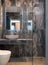 Front view of contemporary gray marble bathroom with vessel bowl sink, mirror back light, glass shower cabin, stone wall and floor
