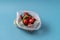 Front view Cucumbers and tomatoes in plastic bag on blue background. Image shows the harmness of using artificial food storage