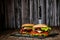 Front view of delicious burgers with beef, cheese, tomato, lettuce on stone board. Selective focus