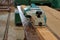 Front view of electric planer on the wooden plank in carpentry workshop