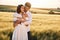 Front view. Embracing each other. Couple just married. Together on the majestic agricultural field at sunny day