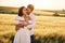 Front view. Embracing each other. Couple just married. Together on the majestic agricultural field at sunny day