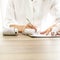 Front view of female bank employee writing something on receipts