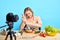 Front view of female chef holds hand blender, clenches teeth, feels frustrated