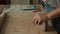 Front view of female potter kneading softly clay on worktop with her hands.