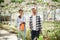 Front view. Florist man and woman are working together in bright greenhouse