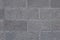 Front view of grey brick wall texture background. Tiled concrete cement surface.