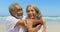 Front view of happy active senior African American man embracing senior woman on the beach 4k