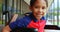 Front view of happy disabled African American schoolboy sitting on wheelchair in school corridor 4k