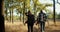 Front view of a happy group of several pairs of people in special hiking clothes with hiking backpacks walking through