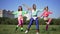 Front view happy slim retro sportswomen exercising to disco music outdoors in sunshine. Wide shot portrait joyful