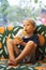 Front view of happy thirsty blond kid boy drinking lemonade, fruit tea, kombucha ice tea with peach and lemon, wellness