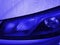 Front view of Headlight classic blue color covered with raindrops. Car exterior details of modern sport car