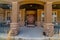 Front view of home with arch porch columns at the entrance and brown front door