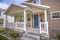 Front view of a home with cozy porch and glass paned bright blue front door