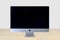 Front view of an iMac computer on a wooden table with a white background