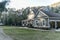 Front view of a large two story blue gray house with wood and vinyl siding