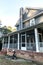 Front view of a large two story blue gray house with wood and vinyl siding