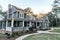 Front view of a large two story blue gray house with wood and vinyl siding