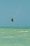 Front view, long distance of a male kiteboarding over tropical water