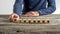 Front view of a man assembling word Discover with wooden cubes