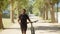 Front view of man with bionic leg walking with bicycle in park