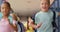 Front view of mixed-race schoolkids with schoolbags running in the corridor at school 4k