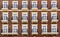 Front view of a modern residential brown brick building with balconies and Windows, close-up, pattern