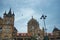 Front view of mumbai central railway station during dark grey moody cloudy day with bird flying over, a city landmark