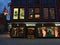 Front view of Nespresso retail store with illuminated shop windows on market place in downtown in the evening.