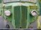 Front view of an old abandoned green rusty 1940s truck