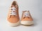 Front view of a pair of light brown sneakers standing on a white background. Studio shot. Leather, suede