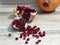 Front view of a pomegranate fruit and seeds on bleached oak wood table background. Punica granatum rustic style photo.