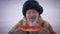 Front view portrait bearded indigenous old man holding sandwich with red caviar looking at camera smiling. Happy