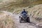 Front view of quad bike zipping along a country road