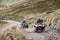 Front view of quad bikes zipping along a country road