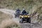 Front view of quad bikes zipping along a country road