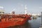 Front view of a red oil tanker sailing through a canal