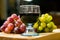 Front view of a red and yellow muscat colored grape and a glass of wine on a wooden board - still life