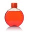 Front view of round transparent bottle full of red liquid soap