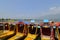 Front view of a row of long flat-bottomed wooden boats, shikaras, on the Dal Lake in Srinagar, India.