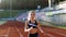 Front view of running caucasian woman in black sportswear doing cardio workout on sports track of stadium. Adult female
