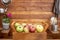 Front view of a rustic wooden home corner with a basket full of apples on the table.  Many vitamins together and a mix of colors