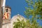Front view of san marti church in the small catalan town of Sant Celoni on a sunny summer day with trees and spanish flags and