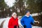 A front view of senior couple jogging in snowy winter nature.