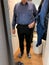 Front view of senior man clothing store fitting room measuring new pair of pants