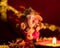 Front view of small ganesha statue and clay lamp against blurred red golden chunari in the background. hinduism concept