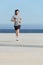 Front view of a sportsman running on the concrete of the seafront