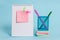 Front view standing spiral blank notebook colored sticky note arrow banners metal pens holder stacked notepads lying